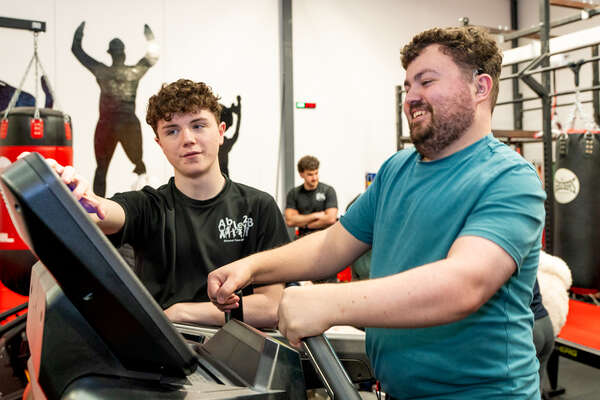 Man assisted on fitness machine